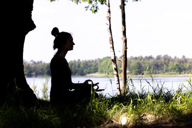 A serene image of a person meditating outdoors, with a focus on relaxation and stress reduction. Soft lighting and nature elements create a calming atmosphere, symbolizing mental well-being amidst financial challenges.