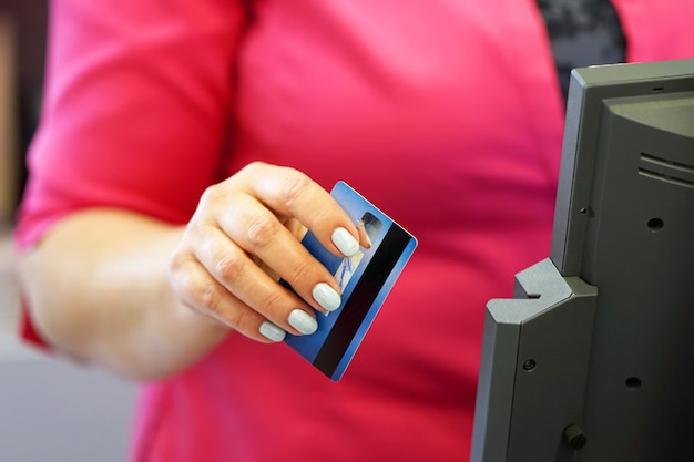 A close-up of a credit card being swiped at a point of sale, with the background blurred showing a busy shopping environment. Symbolizes everyday credit use and its impact on credit score.