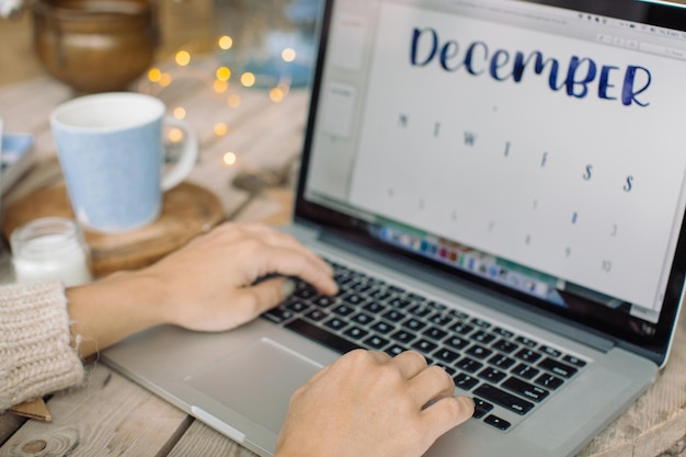 A close-up shot of a freelancer's hands typing on a laptop, with a calendar in the background showing several empty weeks, symbolizing the uncertainty of freelance income.
