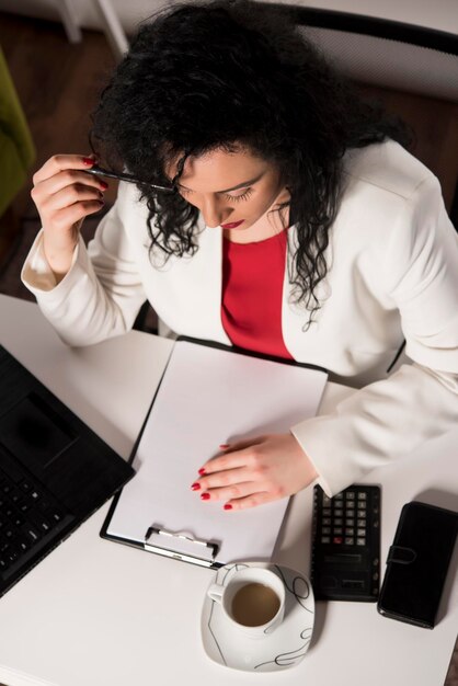 A person reviewing loan documents and making notes, with a calendar and pen nearby, representing proactive debt management.