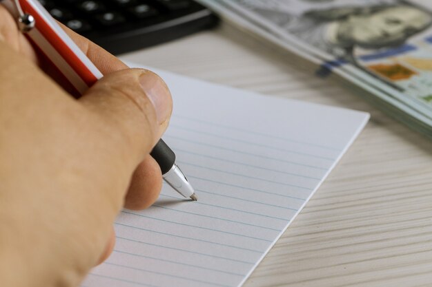 A close-up of a hand holding a checklist with various financial items ticked off. The hand is using a pen and the background is blurred, suggesting a focus on completing the financial review.