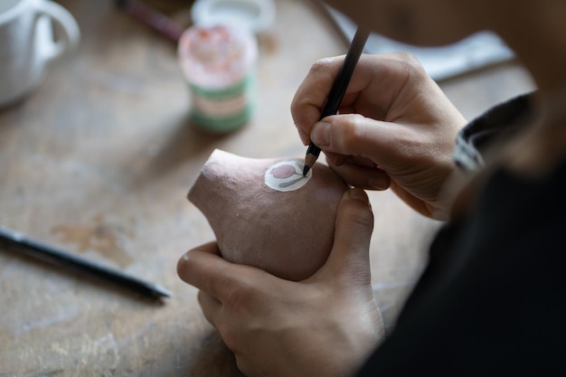 A close-up shot of hands crafting something unique (e.g., jewelry, pottery) with focused attention, symbolizing the dedication required to turn a hobby into a business.