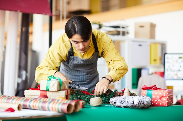 A person working a seasonal job, such as wrapping gifts or serving customers in a festive retail environment, conveying the opportunities for temporary income.
