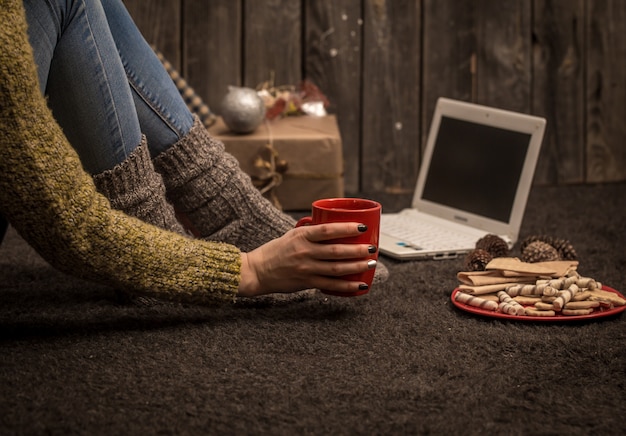 A person working on a laptop at a cozy desk decorated with holiday lights, illustrating the concept of freelance work during the holiday season.