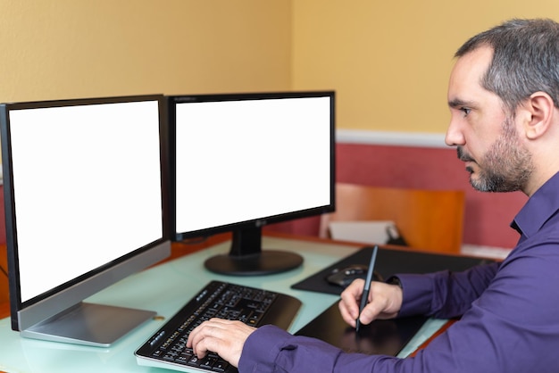 A person sitting at a desk with a laptop, working on multiple screens showing different financial dashboards and investment charts. Natural light streams in from a nearby window. The scene conveys a sense of productivity and control over finances.