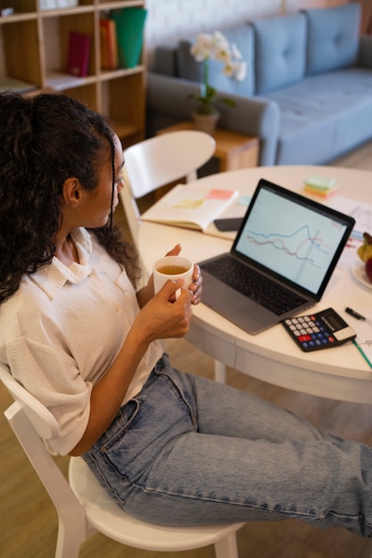 A person using an online salary calculator on a laptop, with graphs and charts surrounding the screen, symbolizing the benefits of using digital tools to understand overtime calculations and financial planning.