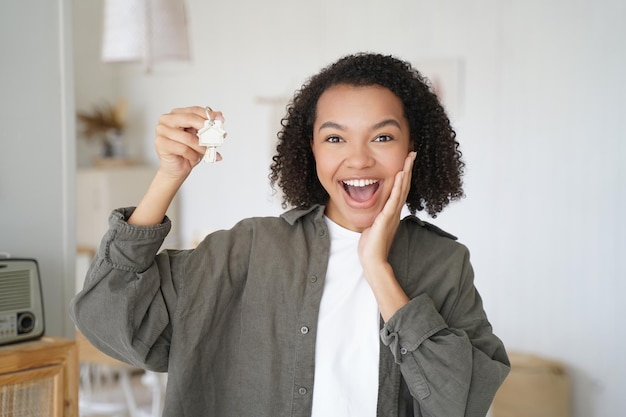 A person smiling and holding keys to a new home, symbolizing financial relief and stability achieved through student loan forgiveness or manageable repayment plans. The photo conveys hope and a positive future.
