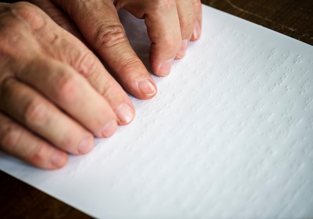 A close-up shot of a hand filling out a government grant application form with a pen. The form is partially visible, showing prompts for personal information and financial details. The background is blurred, focusing attention on the hand and the form.