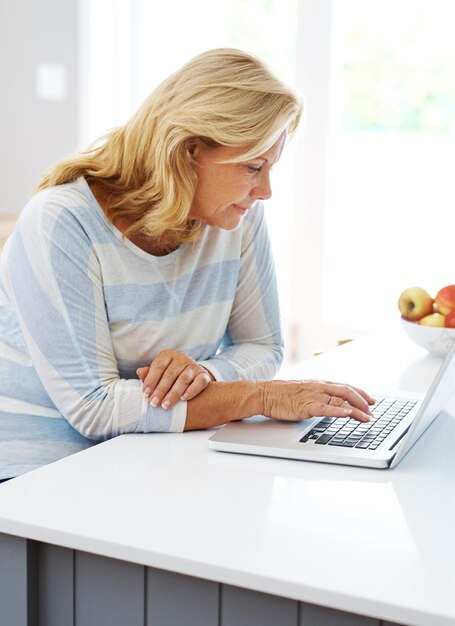 A person sitting at a desk reviewing health insurance plan options on a laptop. The setting is a cozy home office, and the person is focused and engaged in making informed decisions about their healthcare coverage.