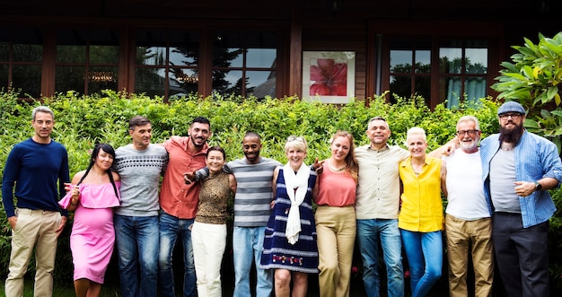 A diverse group of people standing in front of a community center, representing different age groups and ethnicities. The center has a sign that says 