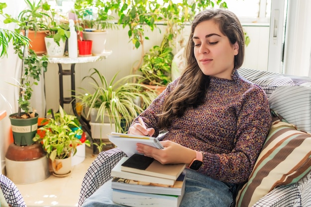 A person calmly using a budgeting app on their tablet while sitting in a peaceful, plant-filled room.