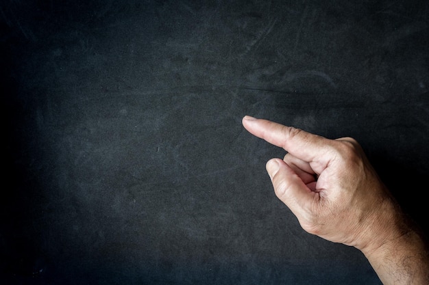 A close-up of a hand pointing at a button on a computer screen that says 
