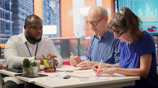 A diverse group of seniors attending a Medicare Part D information session, with a presenter explaining the upcoming changes on a screen, fostering a sense of community and education.